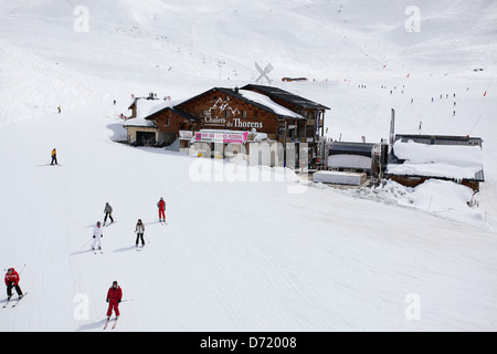 Les Chalets du Thorens con sciatori in primo piano e sullo sfondo. Tipo di viaggio foto da una vacanza di sci nelle Alpi francesi. Foto Stock