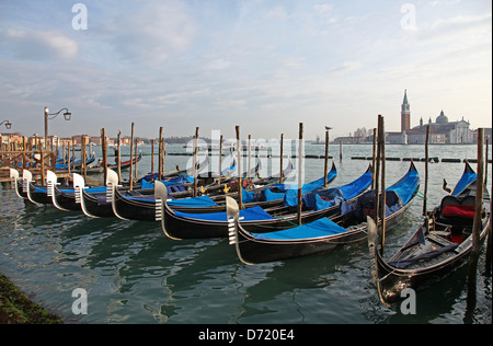 Gondole di fronte all'isola di San Giorgio Maggiore una delle isole di Venezia, Italia settentrionale Foto Stock