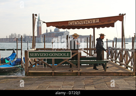 Gondole e gondolieri di fronte all'isola di San Giorgio Maggiore una delle isole di Venezia, Italia settentrionale Foto Stock