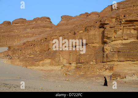 Bedouin uomo a camminare attraverso la sabbia verso il camp Foto Stock
