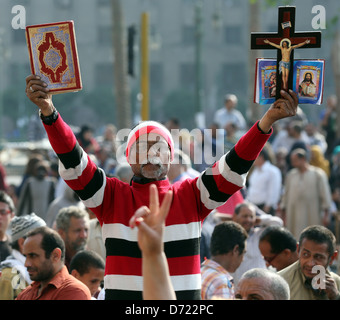 Un uomo egiziano trattiene il santo Corano e una Bibbia cristiana con la croce di legno durante un raduno di massa in piazza Tahrir al Cairo, Egitto Foto Stock