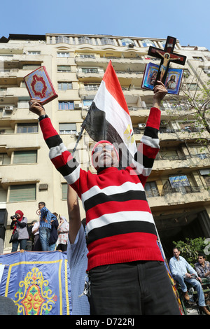 Un uomo egiziano trattiene il santo Corano e una Bibbia cristiana con la croce di legno durante un raduno di massa in piazza Tahrir al Cairo, Egitto Foto Stock