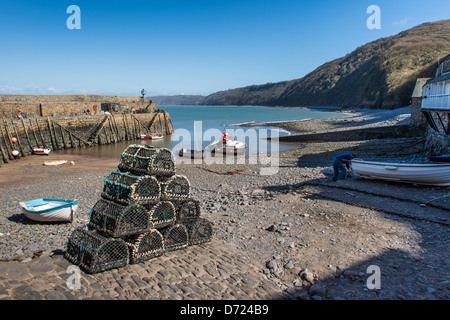Clovelly, Inghilterra. Aragosta e crap pentole a Clovelly Porto, Porto, con la parete del mare e le scogliere del North Devon costa. Foto Stock