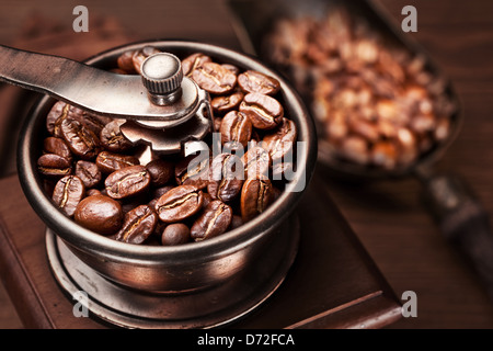 Caffè torrefatto in grani macinati in un macinino da caffè. Foto Stock