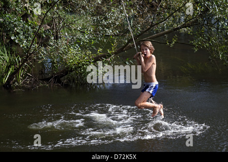 Briescht, Germania, ragazzo basculante in una corda sopra il fiume Spree Foto Stock