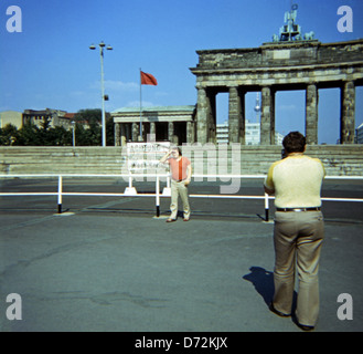 Berlino, Germania, uomo fotografato il suo amico nella parte anteriore del muro di Berlino e Porta di Brandeburgo Foto Stock