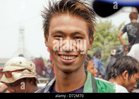 Un giovane uomo di sorrisi per una foto durante il Thingyan Water Festival a Mandalay, Myanmar. Foto Stock