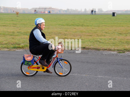 Berlino, Germania, uomo in sella ad una bici per bambini sul campo di aviazione di Tempelhof Foto Stock