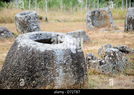 PHONSAVAN, Laos — alcuni dei vasi di pietra nel sito 1 della pianura dei vasi nel Laos centro-settentrionale. Molto rimane sconosciuto circa l'età e lo scopo delle migliaia di vasi di pietra raggruppati nella regione. La maggior parte dei conti datano loro ad almeno un paio di migliaia di anni fa e le teorie sono state presentate che sono state usate nei rituali di sepoltura. Foto Stock