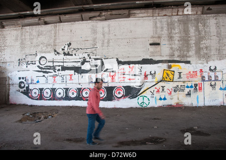 Uomo che cammina davanti Pro-Revolutionary murales Zamalek Cairo Egitto Foto Stock