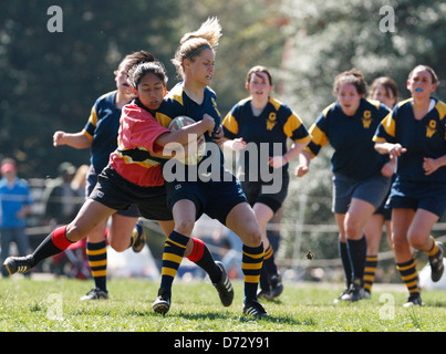 Un George Washington University sfera portante (R) viene affrontato da una Università di Maryland avversario (L) durante una partita di rugby. Foto Stock