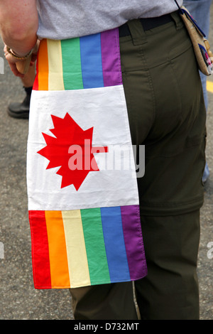 Bandiera canadese in arcobaleno di colori a un Gay Pride marzo, Vancouver, BC, Canada Foto Stock