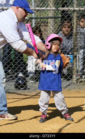 Una bambina baseball la sfera a t t-ball player getting batting istruzione. Foto Stock