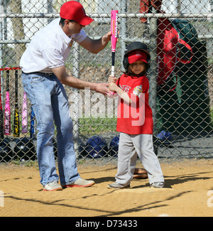 Coach manager ovatta di insegnamento a un raccordo a t t a sfera con sfera di giocatore di baseball. Foto Stock
