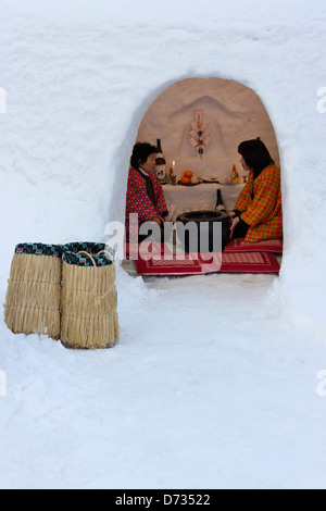 I turisti a mangiare torte di riso e bere sake in igloo-come neve case a Kamakura Festival, Yokote, Prefettura di Akita, Giappone Foto Stock