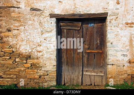 Sgangherate porta di legno nella vecchia casa di pietra anteriore (Grecia) Foto Stock