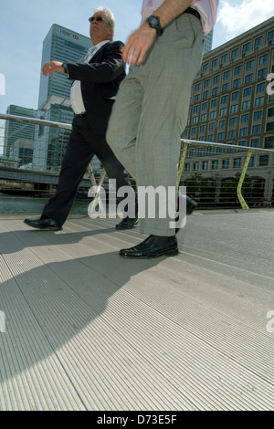 Londra, Regno Unito, imprenditori sul ponte a Canary Wharf Foto Stock