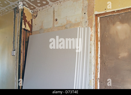 Lastre di cartongesso impilate contro una parete interna come parte delle ristrutturazioni proprietà rilasciato Foto Stock