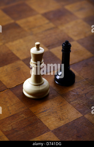 Una regina nera e un re bianco su una scacchiera Foto Stock