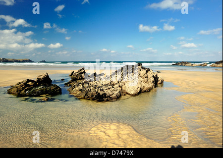 Rocce e piscine a bassa marea su una spiaggia di sabbia Foto Stock