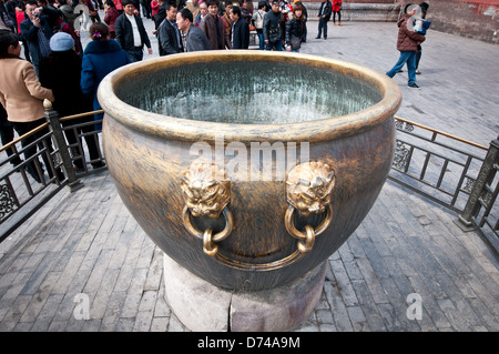 Grande acqua di bronzo ciotola con teste di leone in città proibita a Pechino, Cina Foto Stock