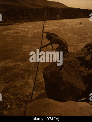 Questa iconica fotografia di Edward Sheriff Curtis cattura "il pescatore" della tribù dei nativi americani Wishram. Riflette la profonda connessione tra le persone e il loro ambiente naturale, evidenziando il lavoro di Curtis sulla vita dei nativi americani. Foto Stock