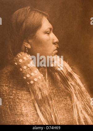 Un ritratto di una Hesquiat Maiden scattato dallo sceriffo Edward Curtis negli anni 1910-1915. La fotografia raffigura una donna nativa americana adornata con gioielli tradizionali, tra cui un anello del naso, che mette in risalto pratiche culturali e abbigliamento indigeni. Foto Stock