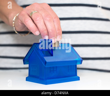 Femmina lato mettere il denaro in casa Foto Stock