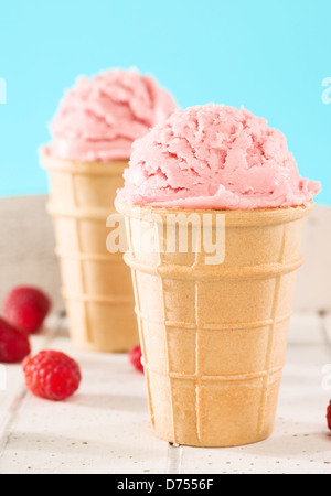 Primo piano di un gelato al lampone in una cialda di bianco su sfondo di legno Foto Stock