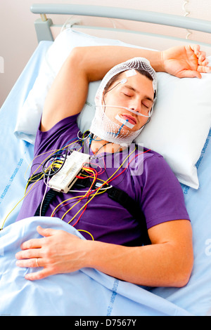 L'uomo sottoposto a esame polysomnographic polisonnografia studio attività fisiologiche del corpo durante il sonno include la misurazione Foto Stock