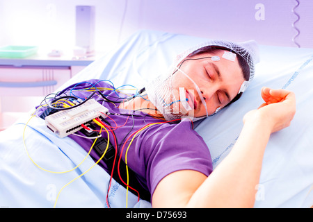 L'uomo sottoposto a esame polysomnographic polisonnografia studio attività fisiologiche del corpo durante il sonno include la misurazione Foto Stock