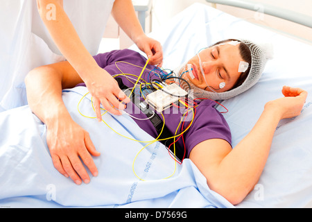 L'uomo sottoposto a esame polysomnographic polisonnografia studio attività fisiologiche del corpo durante il sonno include la misurazione Foto Stock