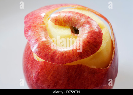 Parzialmente pelato apple rosso su sfondo grigio chiaro Foto Stock