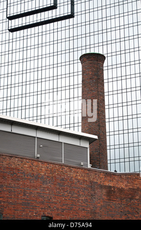 Vecchio e nuovo, camino industriale e palazzo di vetro, Birmingham, Regno Unito Foto Stock