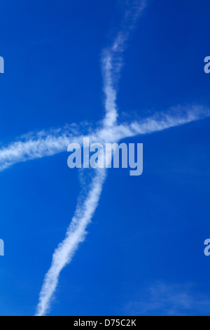 Sentiero di condensazione formando una croce di aria nel cielo Foto Stock