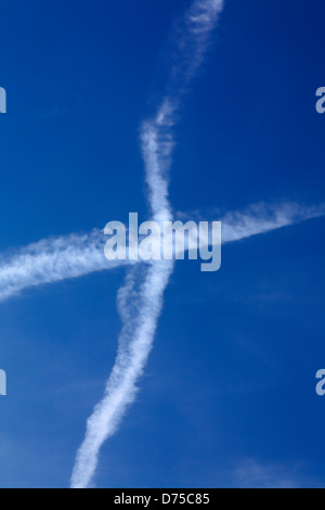 Sentiero di condensazione formando una croce di aria nel cielo Foto Stock