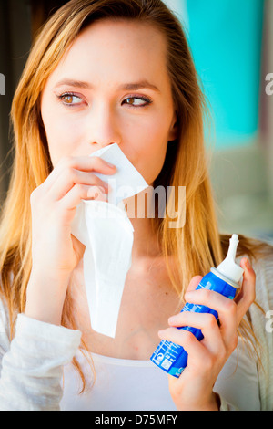 Donna che utilizza un mare sterile spruzzi d'acqua. Foto Stock