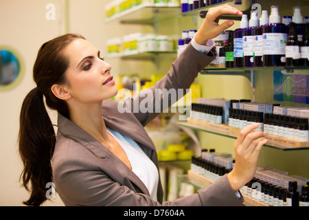 Donna shopping per aromaterapia prodotti in farmacia. Foto Stock