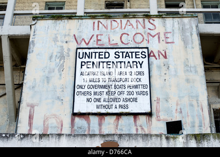 Isola di Alcatraz Indians Welcome Graffiti San Francisco | SAN FRANCISCO, California — Un cartello di avvertimento federale consumato e un graffito rosso con la scritta "Indians Welcome" segnano l'ingresso dell'isola di Alcatraz nella baia di San Francisco. Le parole dipinte sopra il cartello ufficiale del penitenziario risalgono all'occupazione di Alcatraz da parte del gruppo Indians of All Tribes dal 1969 al 1971. La protesta storica vide attivisti nativi americani occupare l'ex prigione federale per 19 mesi, rivendicando l'isola in base a un trattato del 1868 che permetteva ai nativi americani di rivendicare terre federali inutilizzate. L'occupazione divenne un punto di svolta Foto Stock