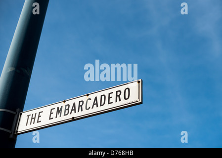 Embarcadero Street Sign San Francisco California // SAN FRANCISCO, California - Un cartello stradale segna l'Embarcadero, la principale strada che corre lungo il lungomare orientale di San Francisco. L'Embarcadero si estende per circa cinque miglia dall'AT&T Park a sud fino al Fisherman's Wharf a nord, servendo come uno dei principali corridoi sul lungomare della città. La strada collega numerosi moli, terminal dei traghetti e attrazioni sul lungomare lungo la baia di San Francisco. Originariamente costruito su terreni pieni, l'Embarcadero divenne un importante viale dopo la rimozione dell'elevato Embarcadero Freewa Foto Stock