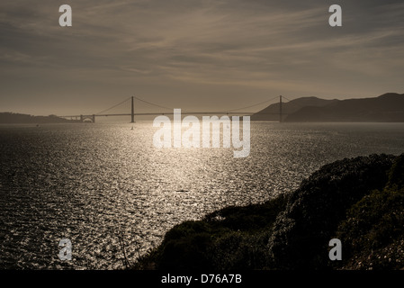 SAN FRANCISCO, California - Una vista del Golden Gate Bridge, che si staglia al sole del pomeriggio, come si vede dall'Isola di Alcatraz nella Baia di San Francisco. Conosciuta per i suoi famigerati detenuti e per la sua inestability, Alcatraz ora funge da importante attrazione turistica e sito di National Park Service, fornendo informazioni sul sistema carcerario e gli eventi storici del 20th ° secolo. Foto Stock