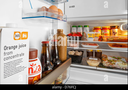 Si raffredda il cibo e le bevande in frigo aperta / frigorifero in cucina Foto Stock