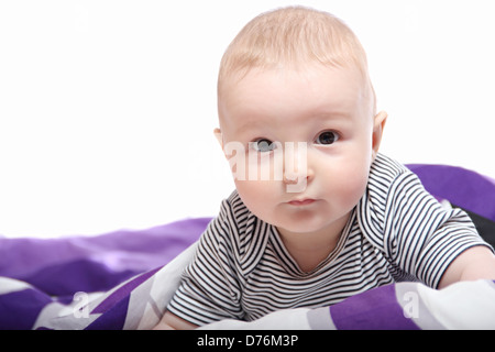 Bambino sul letto sotto coperta Foto Stock