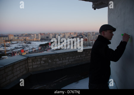 La scrittura graffiti sul muro del tetto al tramonto con la vista sulla città, Voronezh, Russia. Foto Stock