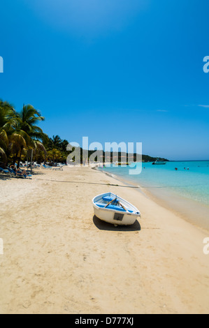 I turisti a languire su una soleggiata spiaggia tropicale mentre è in vacanza nell'Isola di Roatan, Honduras. Foto Stock