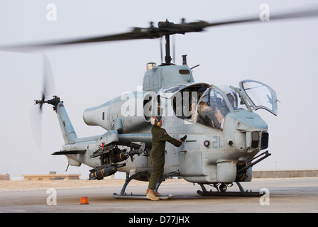 US Marine Corps aviatore si prepara a lanciare Marine Corps AH-1W SuperCobra elicottero d'assalto al Asad Air Base Al Anbar Provincia Foto Stock