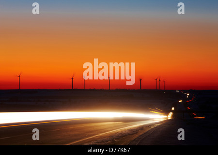 Stati Uniti Kansas luci di striature di macchine passando sulla Interstate Highway sagome distanti le turbine eoliche Foto Stock