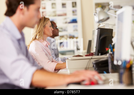 Lavoratori a scrivanie in Occupato Ufficio creativo Foto Stock