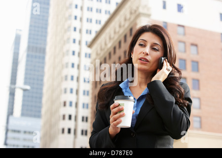 Imprenditrice fuori ufficio sul telefono cellulare Foto Stock