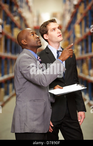 Due imprenditori aventi la discussione in magazzino Foto Stock